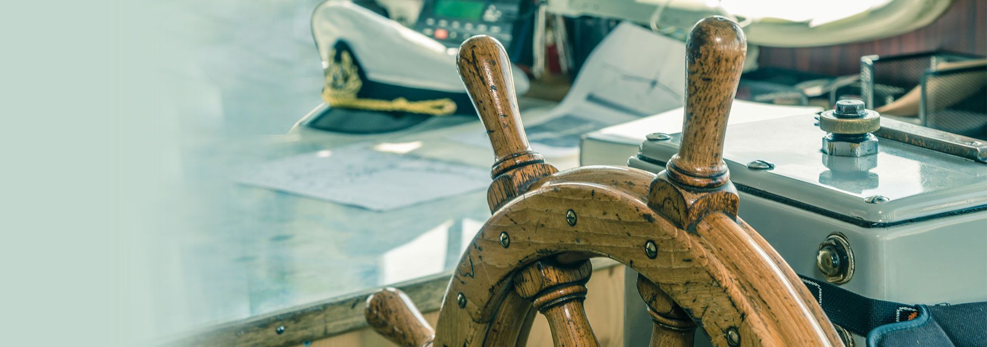 A closeup of the wheel of a classic sailboat